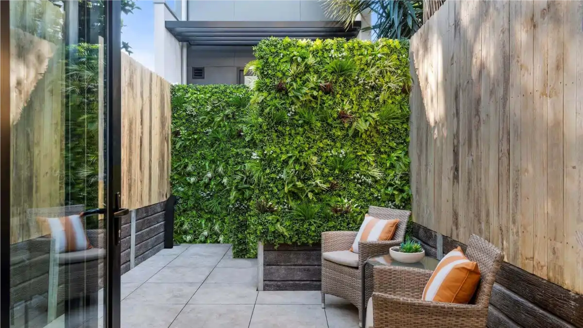 Uma parede verde com plantas híbridas feita na sala da casa. Dicas no Blog Conversa Pronta.