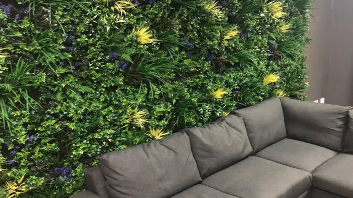 Uma parede verde com plantas mistas feita na sala da casa. Dicas no Blog Conversa Pronta.