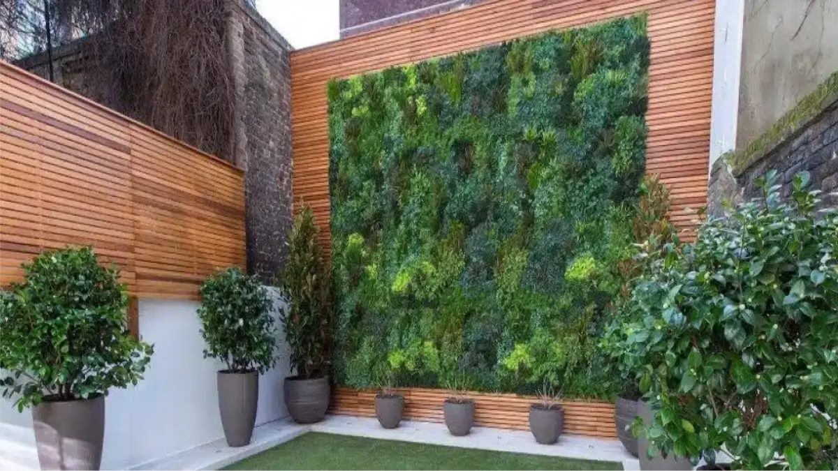 Uma parede verde com plantas feita na sala da casa. Dicas no Blog Conversa Pronta.