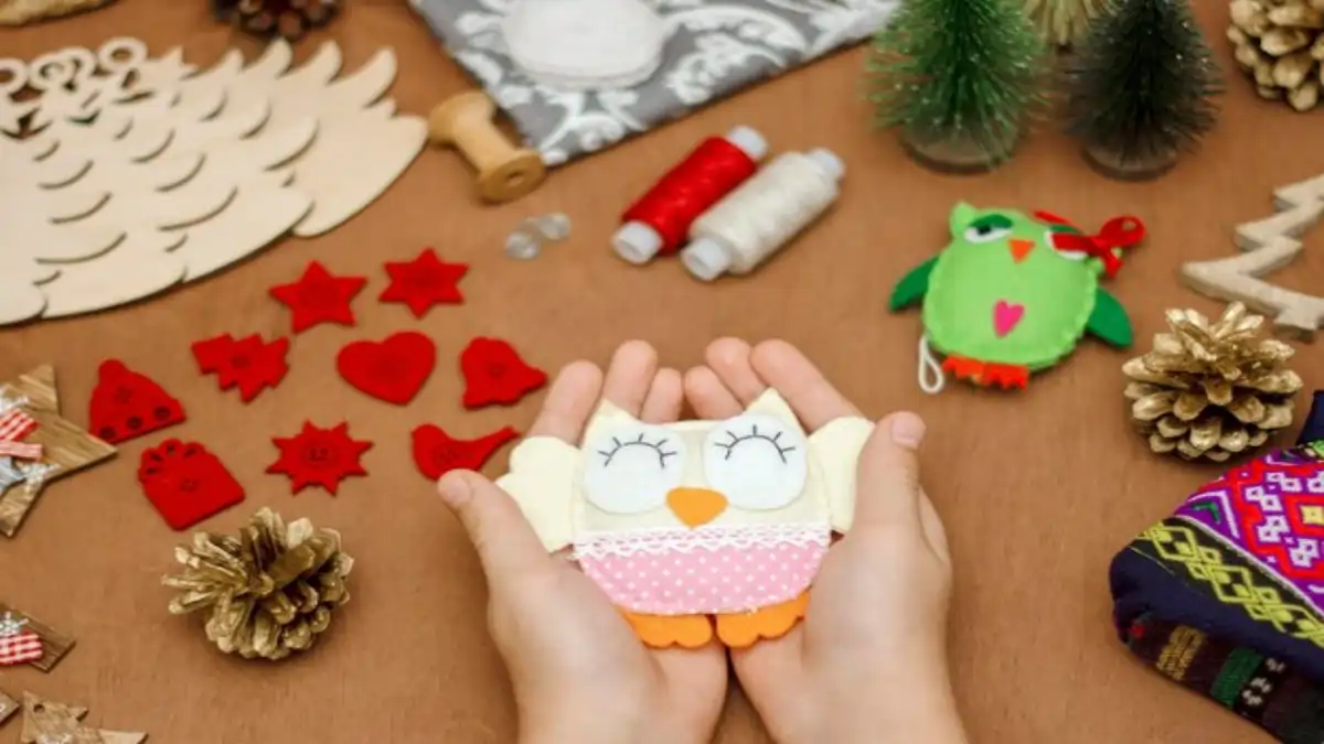 Materiais para fazer artesanato em feltro e mãos segurando um modelo, no blog Conversa Pronta.